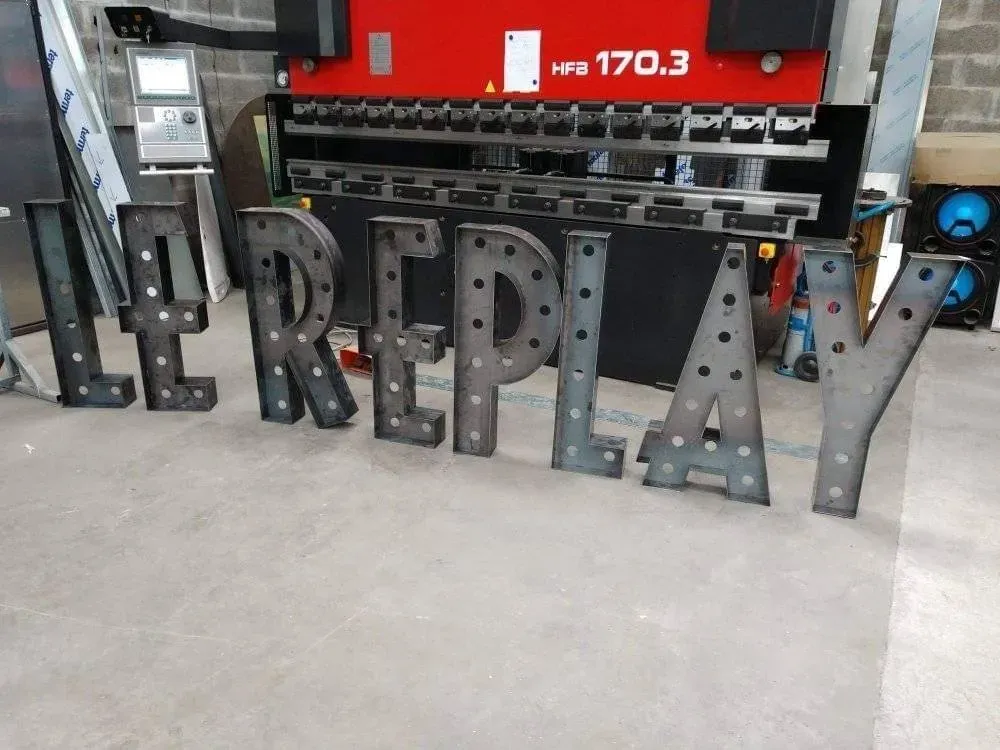 Conception et réalisation d’enseigne en acier découpéwebp